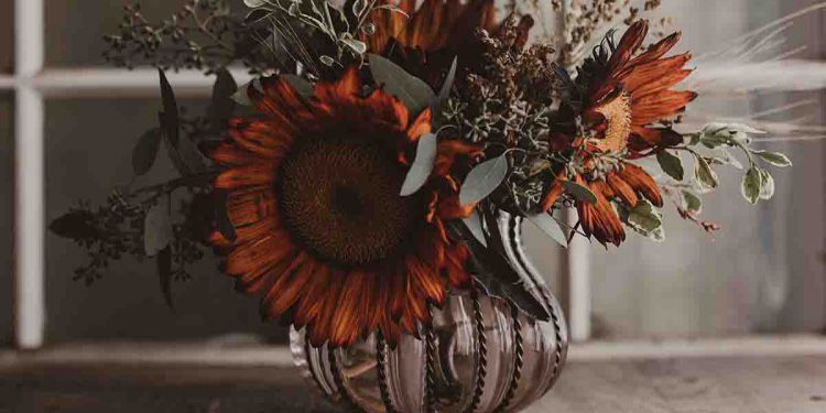 Fall bouquet with orange flowers and pewter vase
