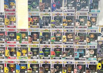 Funko Pop in boxes stacked against a glass wall.
