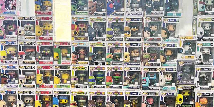 Funko Pop in boxes stacked against a glass wall.