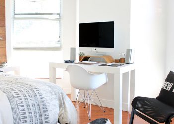White bedroom or dorm room with desk and computer monitor