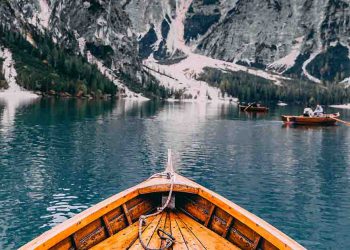 Boat in a lake surrounded by snow covered mountains