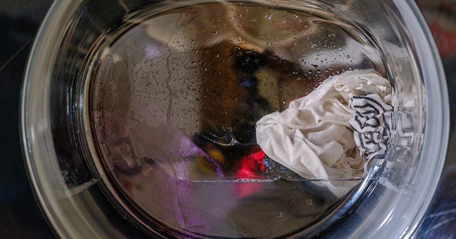 Washing machine window showing clothes in wash cycle