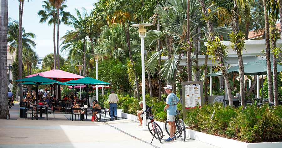 Tourists biking and eating in Miami Beach.