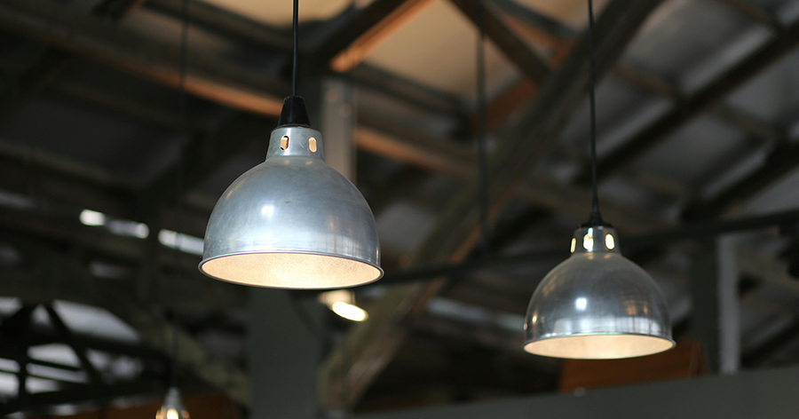 Silver industrial lights hanging from a ceiling