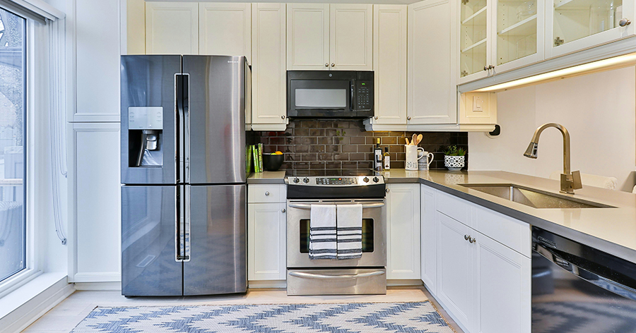 Bright neutral kitchen featuring shot of appliances and cabinets.
