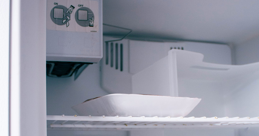 Clean organized freezer with food and ice tray