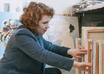 Woman looking through paintings