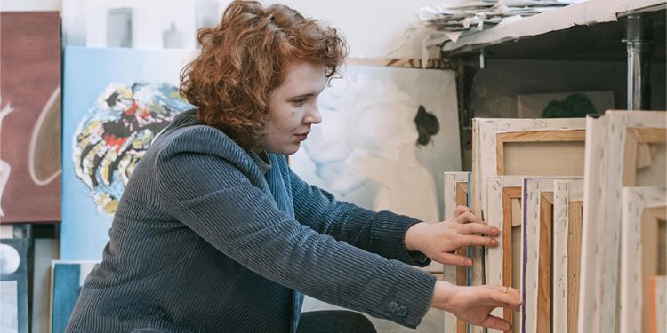 Woman looking through paintings