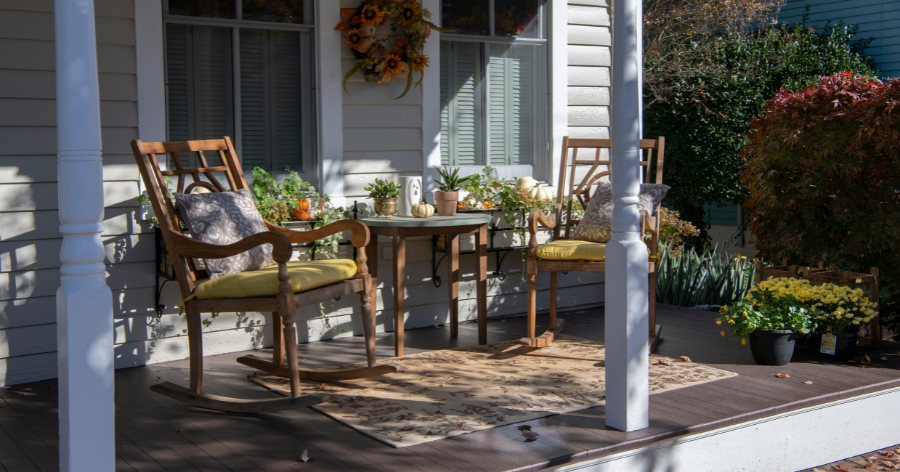 Front porch with simple decorations including plants and furniture.