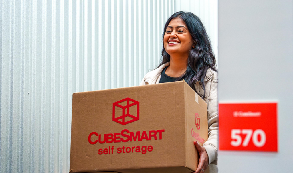 Woman carrying a CubeSmart box to her CubeSmart storage unit.