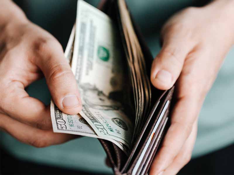 Man opening wallet with bills in it