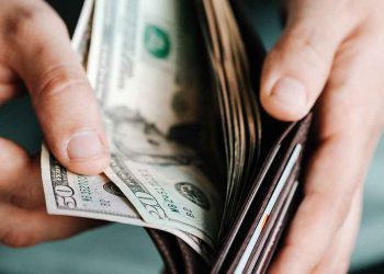 Man opening wallet with bills in it