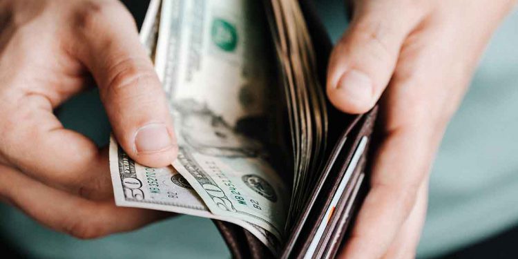 Man opening wallet with bills in it