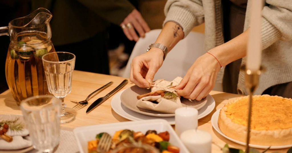 Close-up of a woman setting up an intimate dinner party to celebrate her friend’s bridal shower.