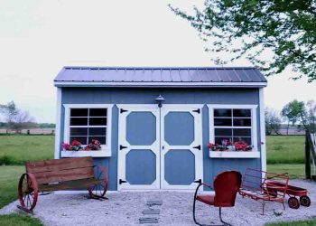 Blue garden shed with white trim in a rock garden
