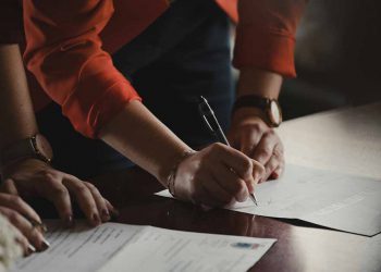 People signing paperwork