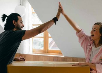 Couple high fiving over cardboard box