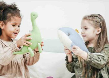 Two girls playing with toys in a playroom