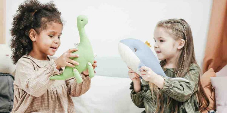 Two girls playing with toys in a playroom