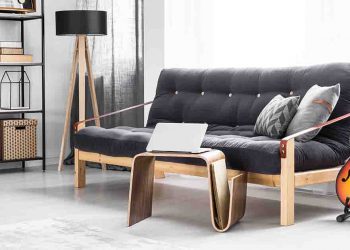 Gray room with couch, guitar, and laptop shown