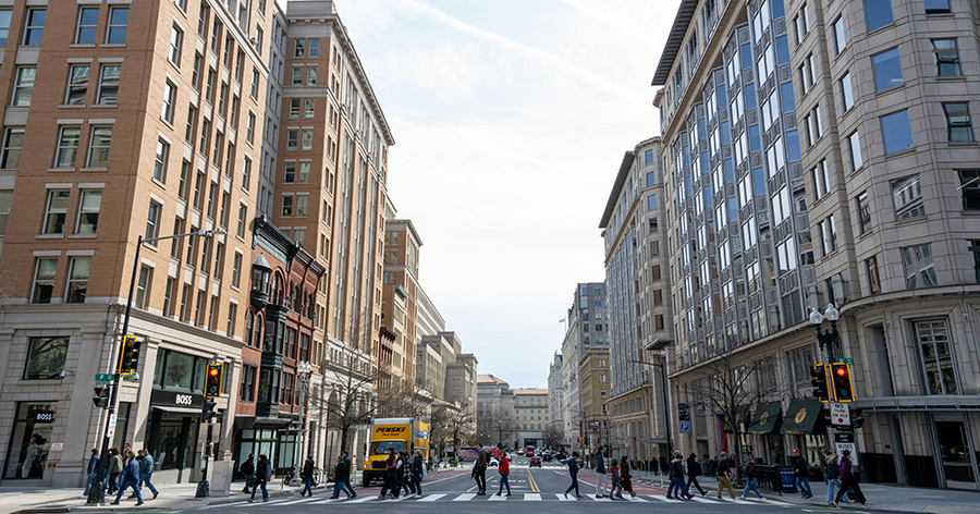 A city with buildings and people crossing the street