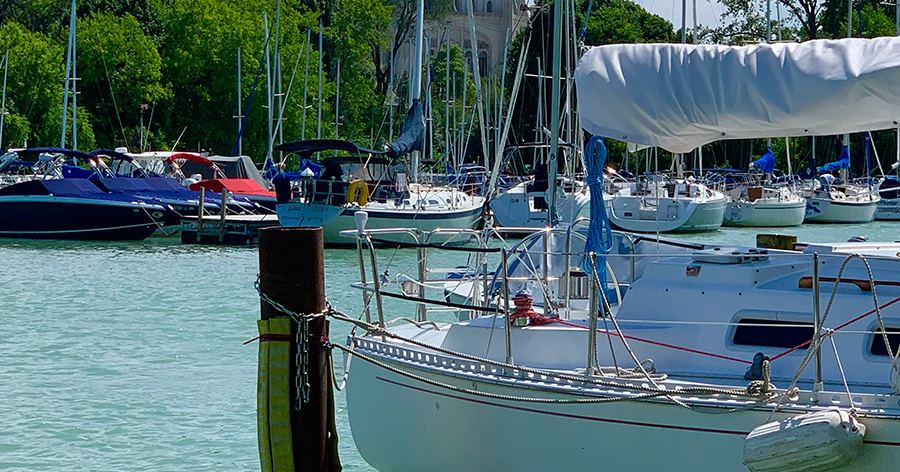 Boat on dock with dome in background and blue water.