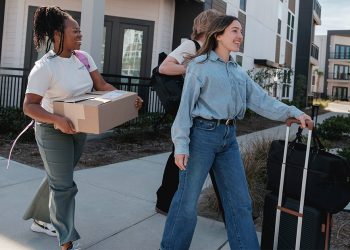Young people moving with boxes and suitcases