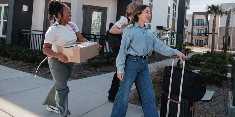 Young people moving with boxes and suitcases
