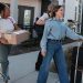 Young people moving with boxes and suitcases