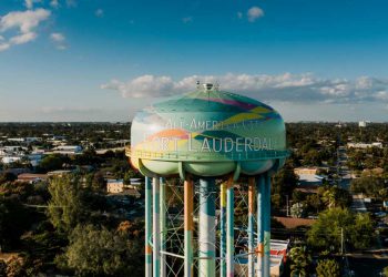 A colorful water tower featuring the words ‘All-America City Fort Lauderdale’ painted on its side, surrounded by the best neighborhoods in Fort Lauderdale
