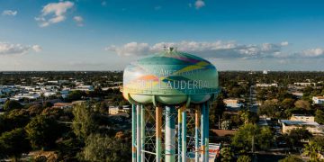 A colorful water tower featuring the words ‘All-America City Fort Lauderdale’ painted on its side, surrounded by the best neighborhoods in Fort Lauderdale