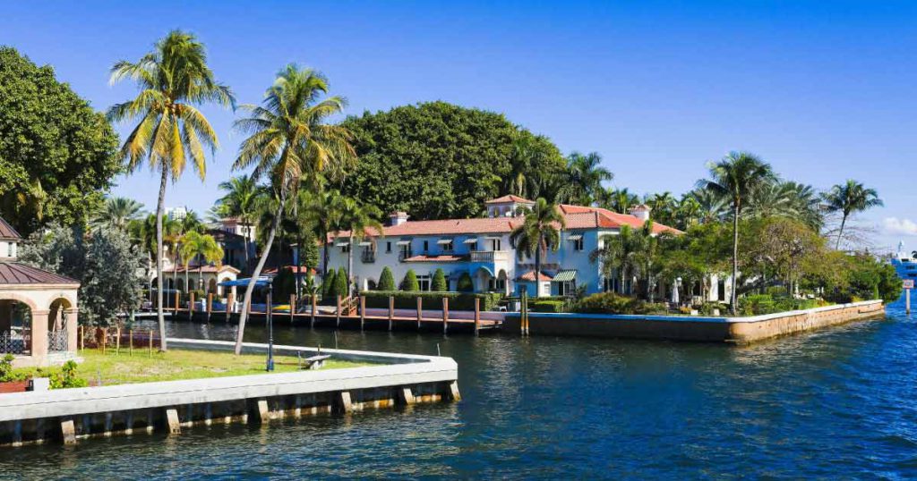 Luxury waterfront homes and palm trees along a canal in one of the best neighborhoods in Fort Lauderdale, showcasing the city’s famous boating lifestyle.