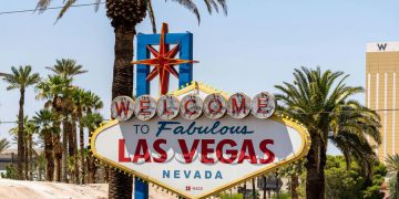 The iconic and colorful “WELCOME TO FABULOUS LAS VEGAS NEVADA” sign surrounded by palm trees on a sunny day.