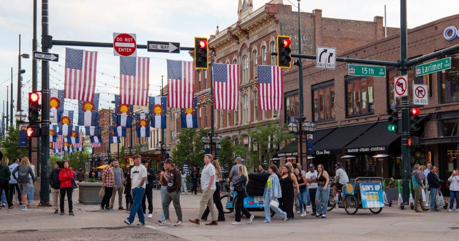 Dozens of pedestrians stroll past storefronts in Larimer Square, where there are lots of fun things to do in Downtown Denver.