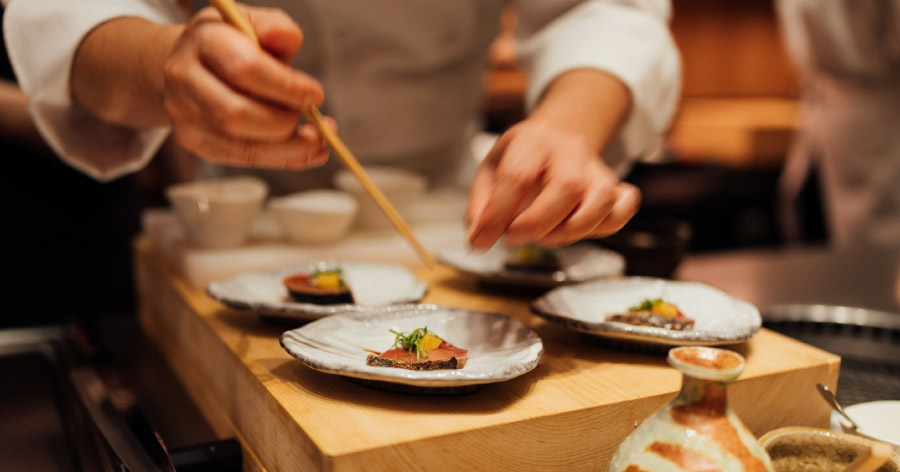 Close-up of a chef preparing dishes at a Japanese omakase restaurant, similar to Kizaki, one of the best fine dining restaurants in Denver.