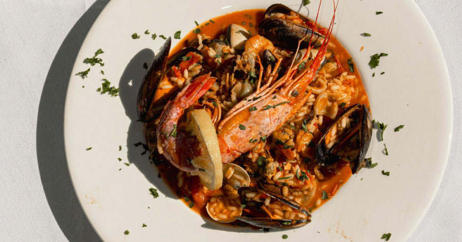 A plate of boiled and seasoned seafood, including crawfish, mussels, and shrimp, similar to dishes served at the best restaurants in Seaport, Boston.