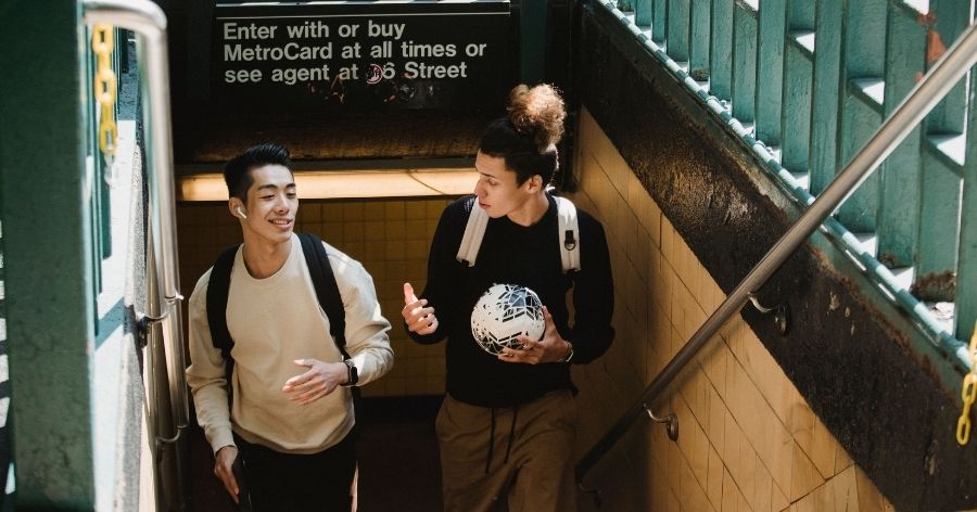 Two college students chatting while leaving a subway station in New York City.