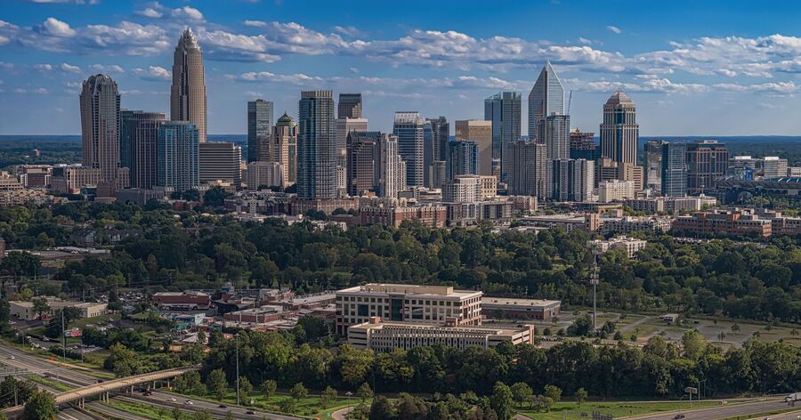 Aerial view of the Charlotte city skyline with Uptown skyscrapers surrounded by some of the best neighborhoods in Charlotte.
