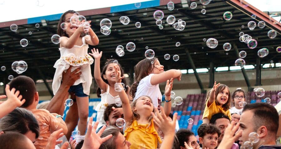 Families enjoying a bubble-filled event inside a stadium while cheering on their favorite team, one of the best things to do in Charlotte, NC, for kids.