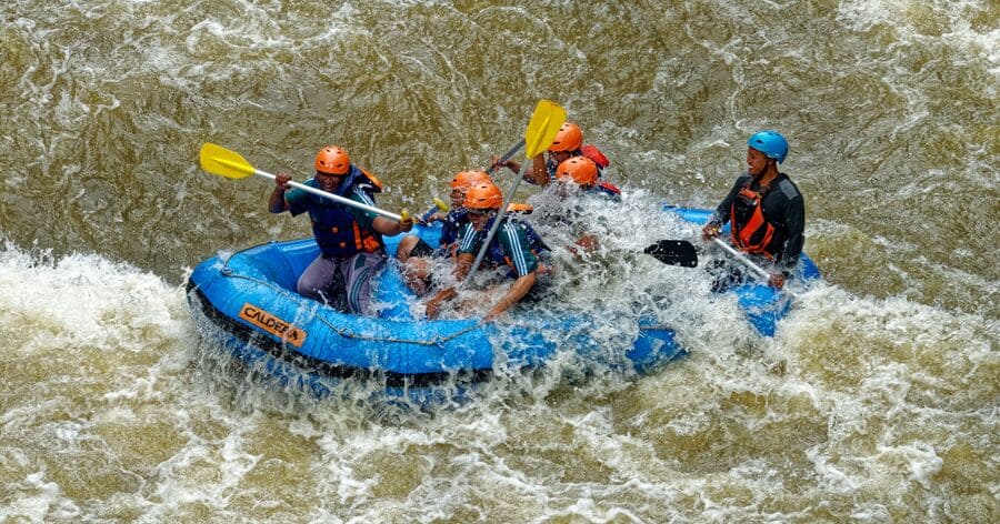 A group of men is having fun whitewater rafting, one of the best things to do in Charlotte, NC, for outdoor adventure.