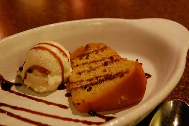 dessert dish of cake and ice cream drizzled with a chocolate sauce