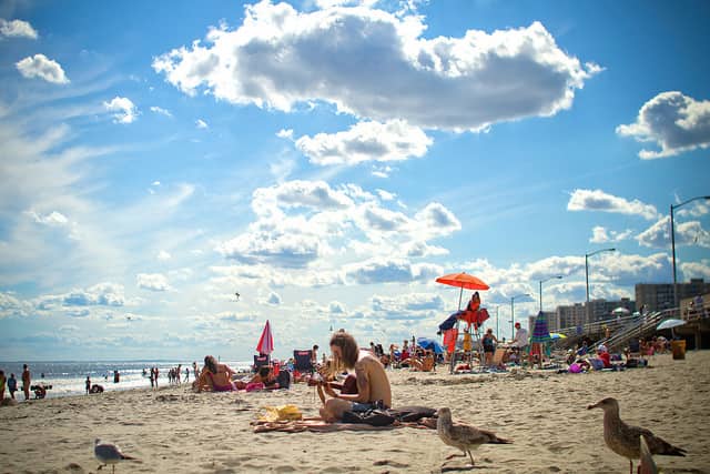 people sitting on Rockaway Beach on a sunny day