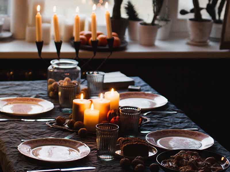 Table decorated for a dinner party with green tablecloth and candles.