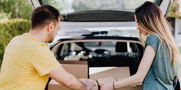 People moving boxes out of trunk
