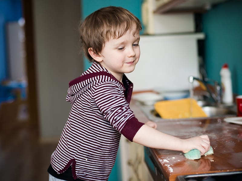 child wiping kitchen counter