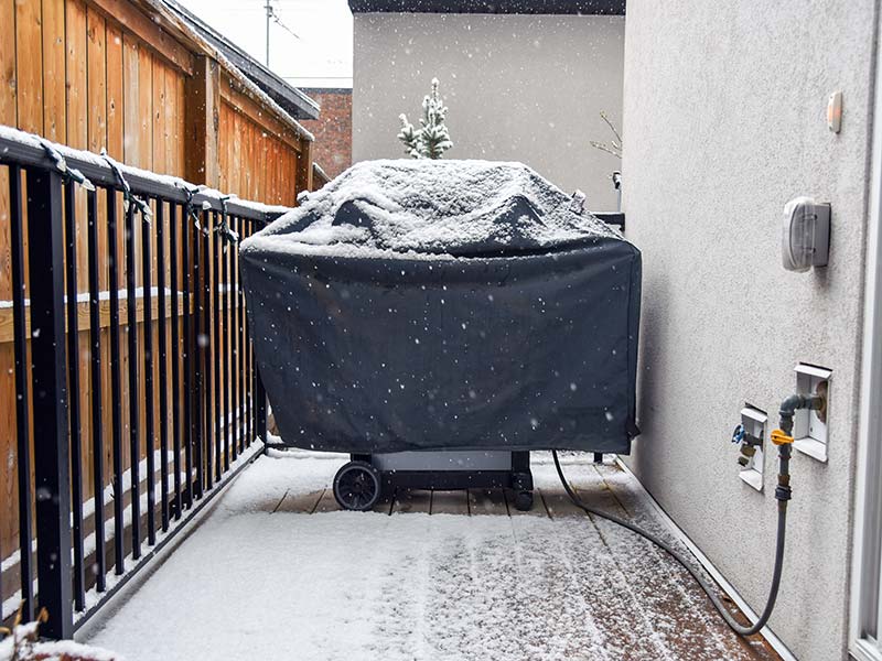 Grill with cover on in the snow
