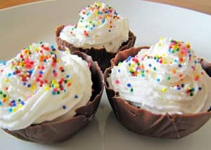 Whipped cream with sprinkles swirled in chocolate cups
