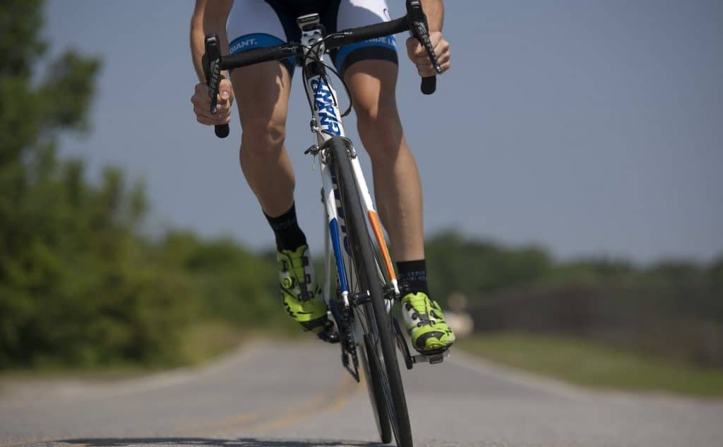 person biking on a road during a sunny day