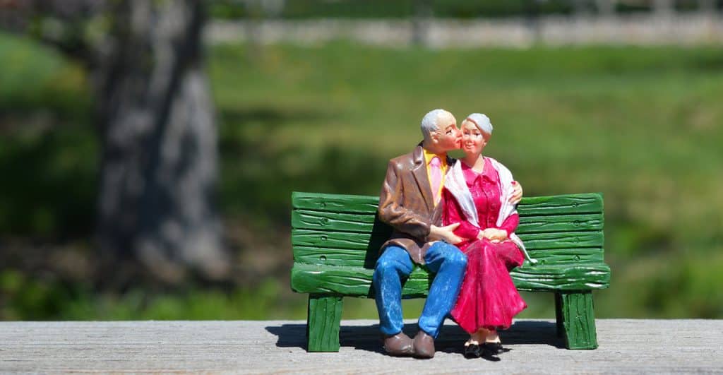 older couple sitting on a bench-retirement