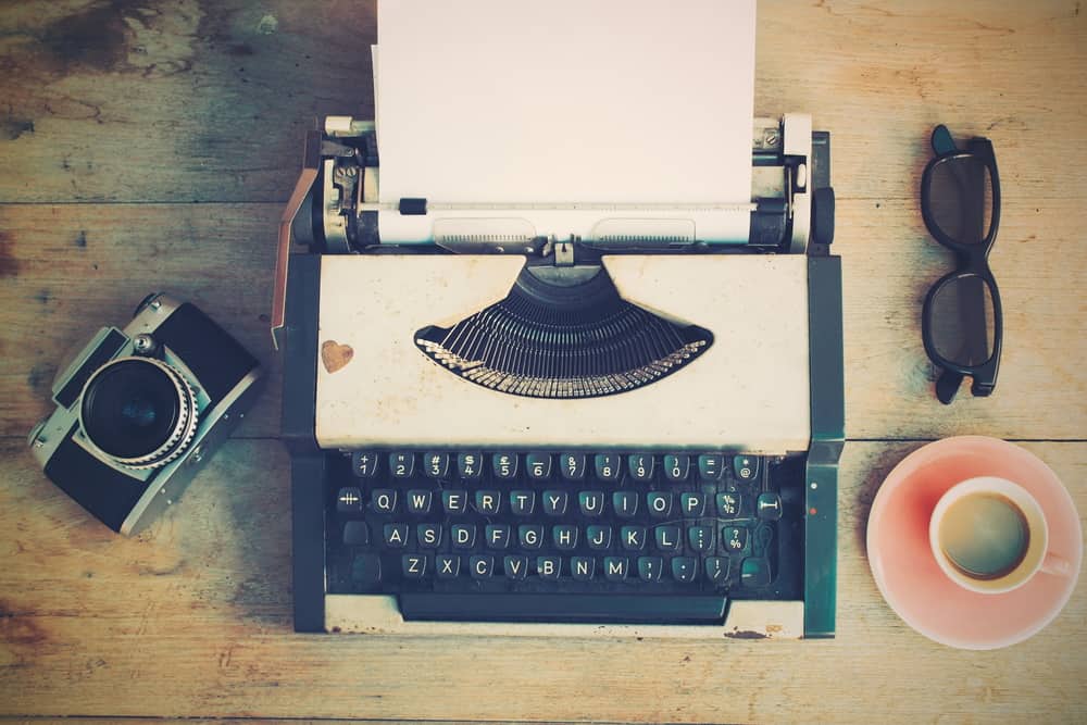 old typewriter and camera on a table